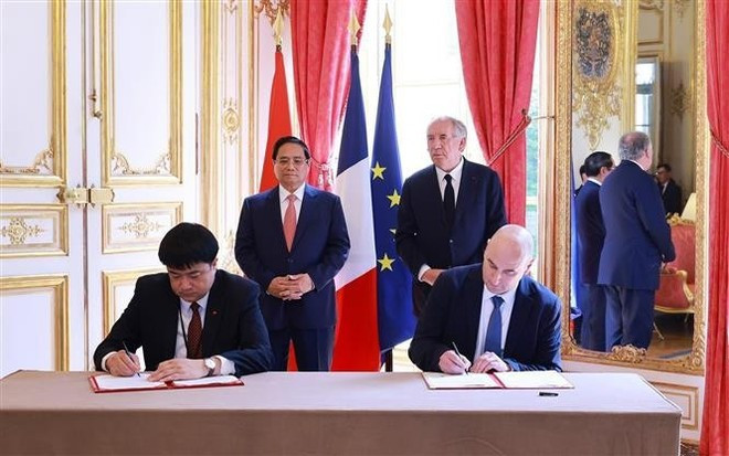 Vietnamese Prime Minister Pham Minh Chinh and his French counterpart Francois Bayrou witness the signing of a Memorandum of Understanding between the Viet Nam Academy of Science and Technology, and the French Alternative Energies and Atomic Energy Commission. (Photo: VNA) Vietnamese Prime Minister Pham Minh Chinh and his French counterpart Francois Bayrou witness the signing of a Memorandum of Understanding between the Viet Nam Academy of Science and Technology, and the French Alternative Energies and Atomic Energy Commission. (Photo: VNA)