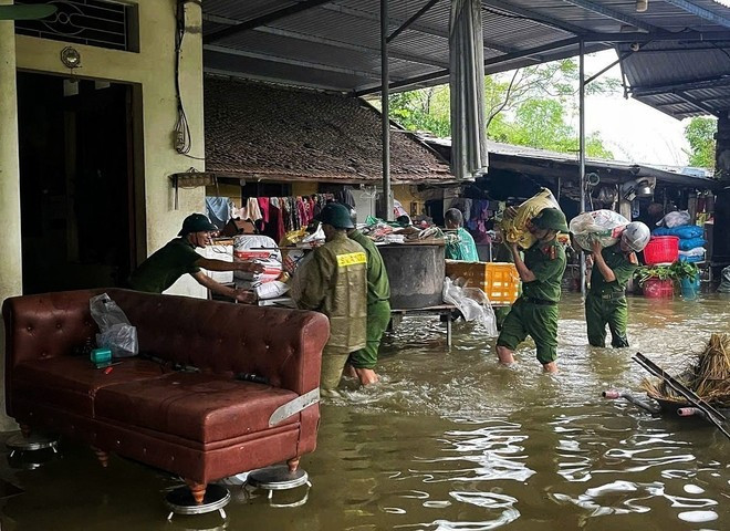Police and security forces help people move their assets in a flooded area. (Photo: VNA) Police and security forces help people move their assets in a flooded area. (Photo: VNA)
