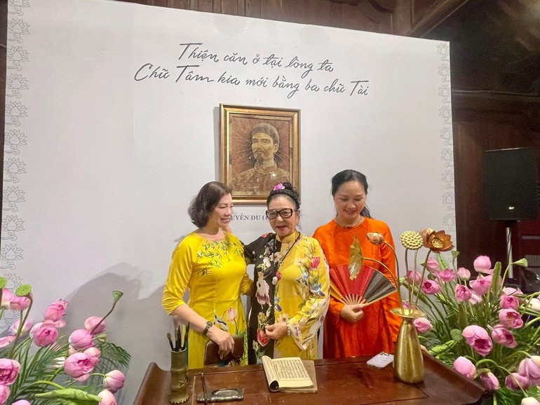 Visitors take photos in front of a portrait of great poet Nguyen Du made from dried lotus leaves sen2.jpg