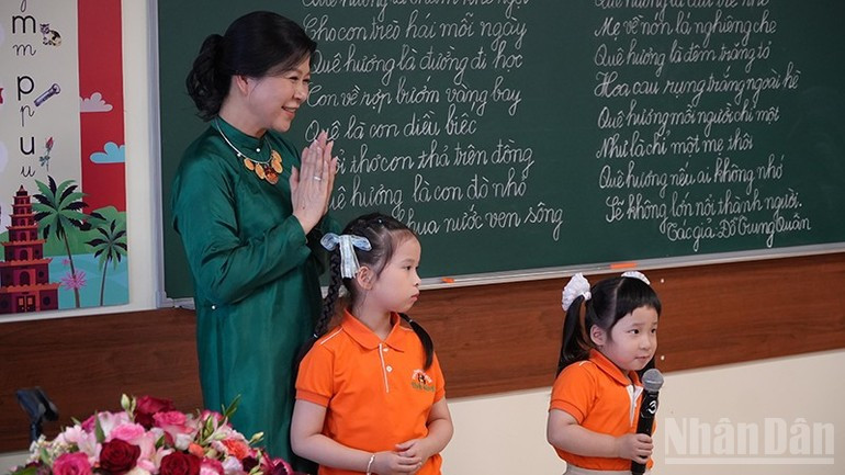 Ngo Phuong Ly listens to children recite poetry. h2.jpg