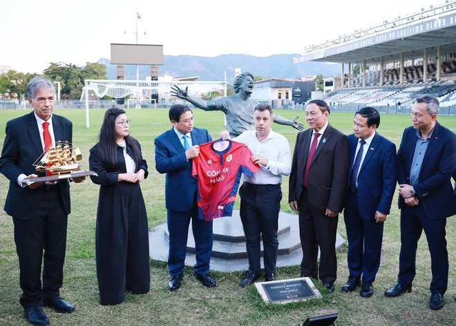 PM Pham Minh Chinh (3rd from left) presents a jersey of the Ha Noi Football Club to the Vasco da Gama Football Club's representative. (Photo: VNA) PM Pham Minh Chinh (3rd from left) presents a jersey of the Ha Noi Football Club to the Vasco da Gama Football Club's representative. (Photo: VNA)