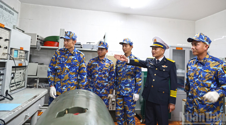 Colonel Nguyen Dinh Manh, Political Commissar of Brigade 170, inspects technical support work in the control room of Station A3.