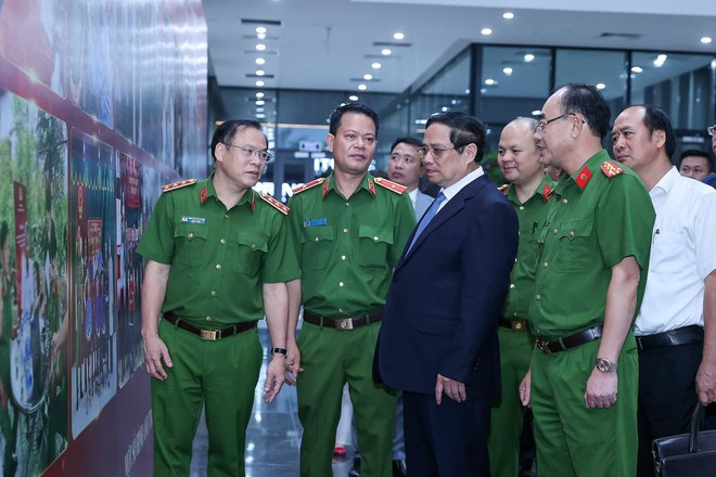 PM Pham Minh Chinh and public security officials look at photos on martyrs' DNA testing activities. (Photo: VNA) PM Pham Minh Chinh and public security officials look at photos on martyrs' DNA testing activities. (Photo: VNA)