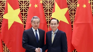 Vietnamese Politburo member and Minister of Foreign Affairs Le Hoai Trung (right) welcomes Chinese Politburo member and Minister of Foreign Affairs Wang Yi in Ha Noi on March 15. (Photo: VNA)