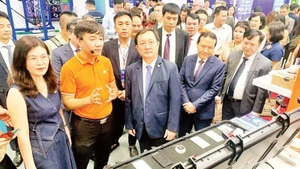 Scientists visit a technology product exhibition area at the Viet Nam Technology and Innovation Connectivity event.