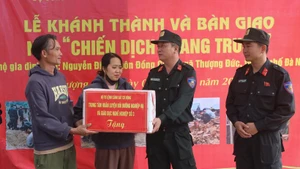 Lieutenant Colonel Pham Hong Phuc (right) from Mobile Police Command congratulates a couples in Thuong Duc commune, Da Nang city, on their new house built by the police force. (Photo: VNA)
