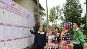 The head of Polling Team No. 5 in Quy Mong commune, Lao Cai province, introduces the lists of candidates to local residents. (Photo: VNA)