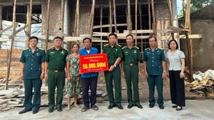 Veteran Pham Van Luong (centre) receives support to build a new home. (Photo: NGOC LAN)