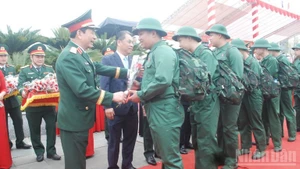 General Phan Van Giang, Minister of National Defence, presents flowers to new recruits heading off to perform their duties.