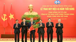 Party General Secretary To Lam (third, left) is awarded the 45-year Party membership badge. (Photo: nhandan.vn)