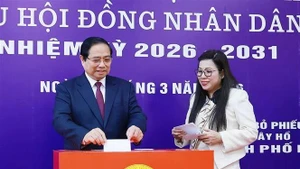 Prime Minister Pham Minh Chinh and his spouse cast ballots at Polling Station No. 21 in Tay Ho ward, Ha Noi, on March 15 morning. (Photo: VNA)