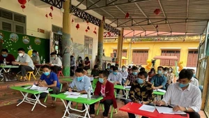 Party members attend a model Party cell meeting in Huoi Hau Village.
