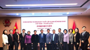 Participants pose for a group photo at the ceremony to mark the 76th founding anniversary of the diplomatic relations between Viet Nam and China in Chongqing. (Photo: VNA)