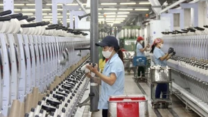 Workers at Hoang Thi Loan Garment Joint Stock Company operate a production line. (Photo: MAI HOA)