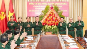 General Nguyen Trong Nghia, Politburo Member, Secretary of the Party Central Committee, Member of the Standing Board of the Central Military Commission, and Head of the General Department of Politics of the Viet Nam People's Army, presents flowers to congratulate the Academy of Politics on the occasion of the 43rd Vietnamese Teachers’ Day. (Photo: VNA)