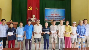 Representatives of Nhan Dan Newspaper in Quang Tri hand over cash donations to households in Hoi Ky Hamlet, Nam Hai Lang Commune.
