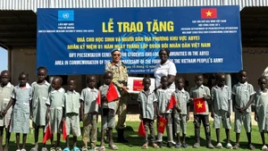 Lieutenant Colonel Tran Thanh Son, Deputy Commander of Viet Nam’s Engineering Unit No. 4, presents school supplies to Abyei students. (Photo: HAI YEN)
