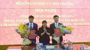 Deputy Minister of Agriculture and Environment Nguyen Thi Phuong Hoa presents the appointment decision to Chu An Truong, Deputy Head of the Department of Land Administration, appointing him as Director General of the Centre; and to Nguyen Dac Nhan, Deputy Head of the Department of Land Management, appointing him as Deputy Director General of the Centre. (Photo: TRUONG GIANG)