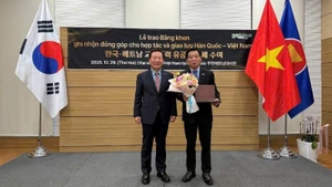 Park Hyeon Guk, Head of Bonghwa County (the RoK), presents an insignia to Vu Ho, Vietnamese Ambassador to the RoK.
