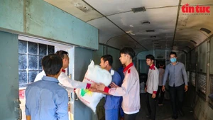 Railway workers load relief packages into train to deliver to flood-hit communities. (Photo: VNA)