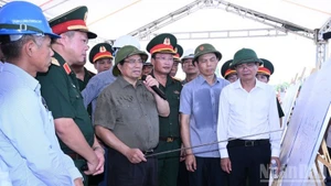 Prime Minister Pham Minh Chinh (C) inspects the construction site of the new Phong Chau bridge in Phu Tho (Photo: nhandan.vn)