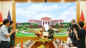 Deputy Defence Minister Senior Lieutenant General Hoang Xuan Chien (R) presents a certificate of merit from the Minister of National Defence of Viet Nam to USAID's Mission Director for Vietnam Aler Grubbs (Photo: VNA)