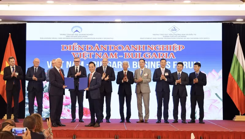 Bulgarian President Rumen Radev (sixth from the right) and other delegates witness representatives of Vietnamese and Bulgarian businesses exchanging cooperation agreements at the forum. (Photo: VNA)