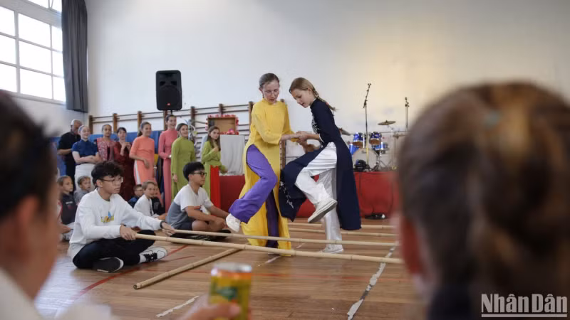 French girls wear ao dai while doing the bamboo dance. French girls wear ao dai while doing the bamboo dance.