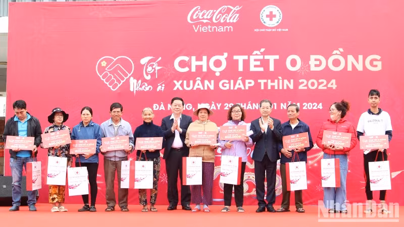 Head of the PCC’s Commission for Communication and Education Nguyen Trong Nghia grants Tet gifts to needy households at the fair. (Photo: NDO)
