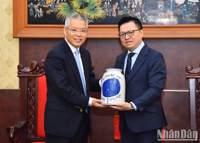 Le Quoc Minh presents a souvenir to Hu Zhaoming.