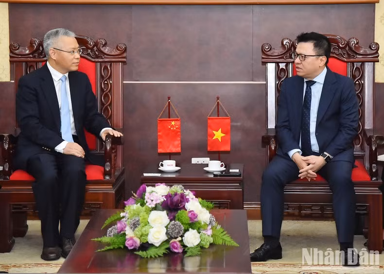 Editor-in-Chief of Nhan Dan Newspaper Le Quoc Minh receives Hu Zhaoming, Spokesperson and Director General of the Bureau of Public Information and Communication, International Department of the CPC Central Committee.