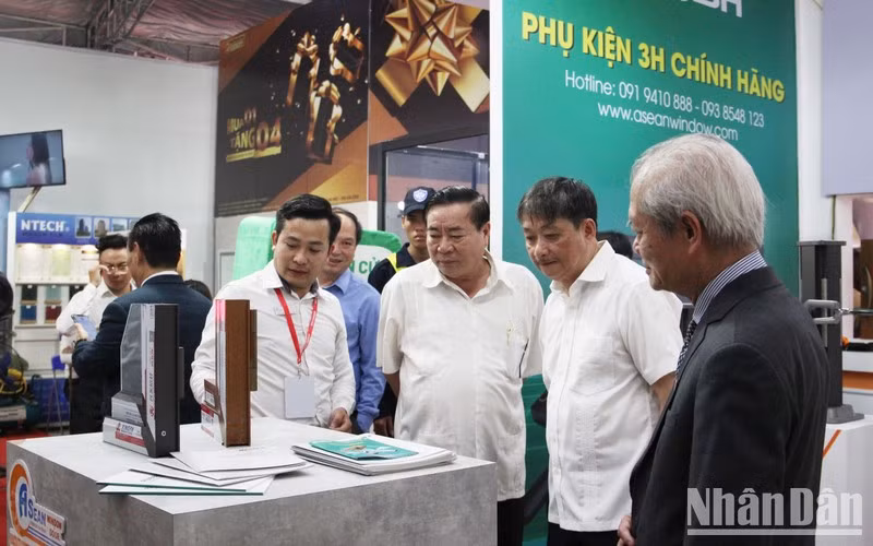 Delegates visit a booth at the exhibition. (Photo: NDO)