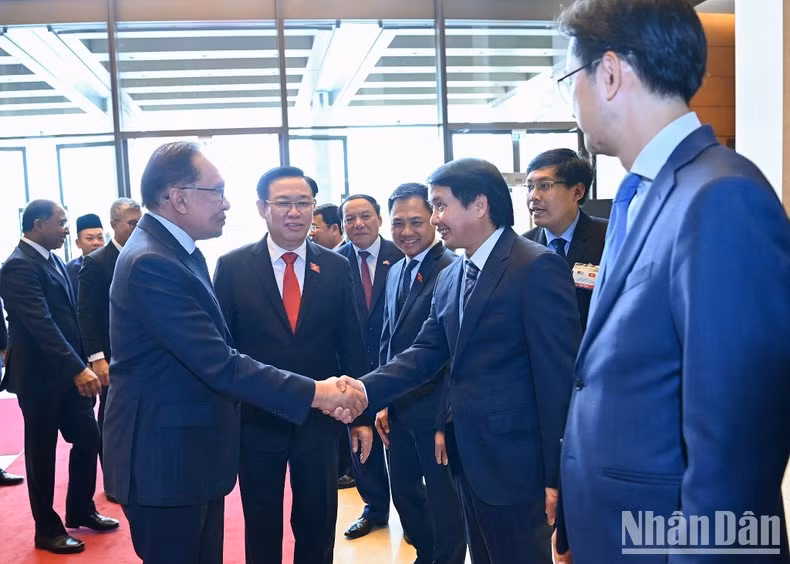 NA Chairman Vuong Dinh Hue introduces members of the Vietnamese delegation attending the reception to the Malaysian Prime Minister.