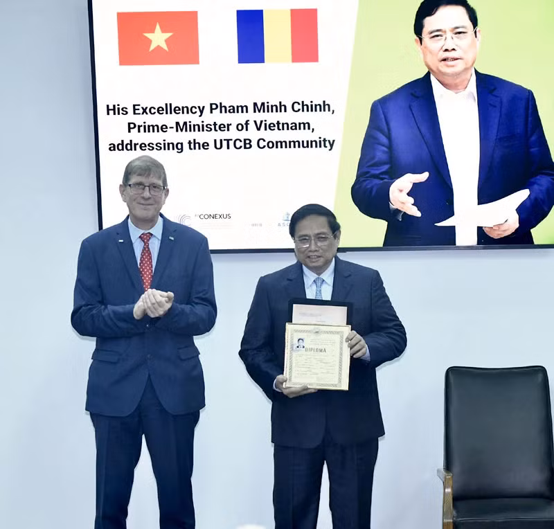 PM Pham Minh Chinh receives his student record from the UTCB's rector (Photo: VNA)