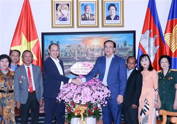 Lieut. Gen. Nguyen Van Nam, Commander of the Ho Chi Minh City High Command (fourth, left) presents flowers to Cambodian Consul General in HCM City Chan Sorykan on the occasion of the January 7 Victory (Photo: VNA)