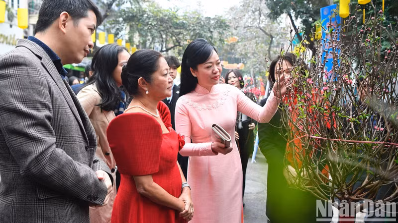 Phan Thi Thanh Tam, the spouse of President Vo Van Thuong introducing Louise Araneta Marcos, the spouse of the President of the Philippines the meaning of peach blossom branches on Tet.