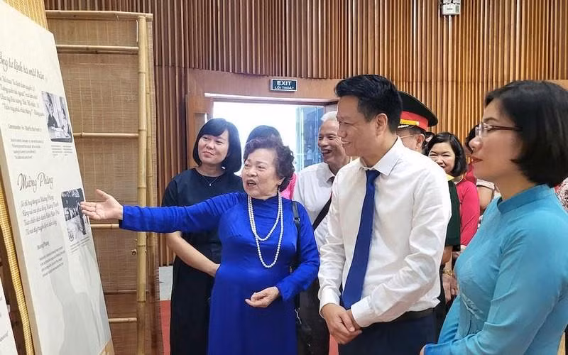 Poet-journalist Nguyen Thi My Dung recites her poem to the visitors at the exhibition 