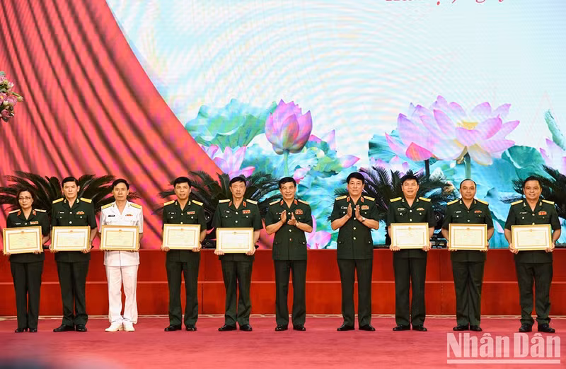 Minister of National Defence General Phan Van Giang and General Luong Cuong, Chairman of the General Department of Politics of the Vietnam People's Army, present certificates of merit from the Ministry of Defence, to collectives.