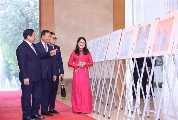 The two leaders visit photo exhibition featuring the land and people of Vietnam and Cambodia, and their good relations (Photo: VNA)