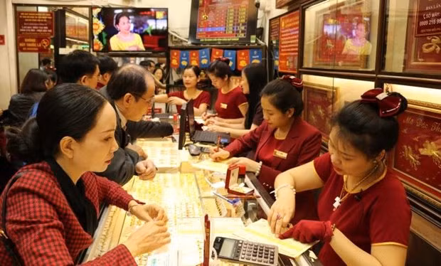 Customers make transactions at a Bao Tin Minh Chau gold shop. (Photo: VNA)