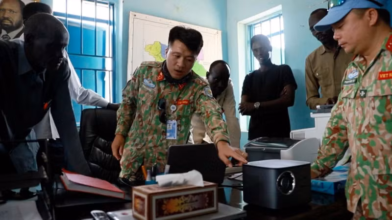 A member of Viet Nam’s Engineering Unit Rotation 3 instructs Abyei Department of Education staff on how to install and operate the donated office equipment.