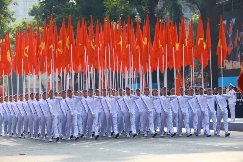 The procession of the Party and national flags passes by the grandstand. (Photo: VNA)