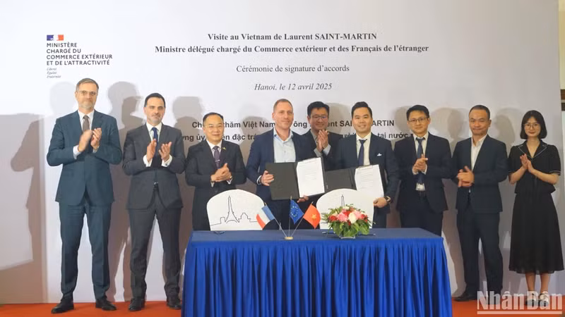 Laurent Saint-Martin, Minister Delegate for Foreign Trade and French Nationals Abroad (back row, second from left), and delegates witness representatives of businesses from the two countries signing cooperation agreements. (Photo: TRUNG HUNG)