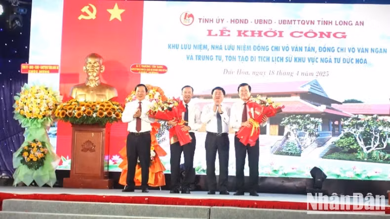 Secretary of Long An Provincial Party Committee Nguyen Van Quyet (second from right) and Chairman of Long An Provincial People's Committee (first from left) present flowers to former President Truong Tan Sang and the sponsor.