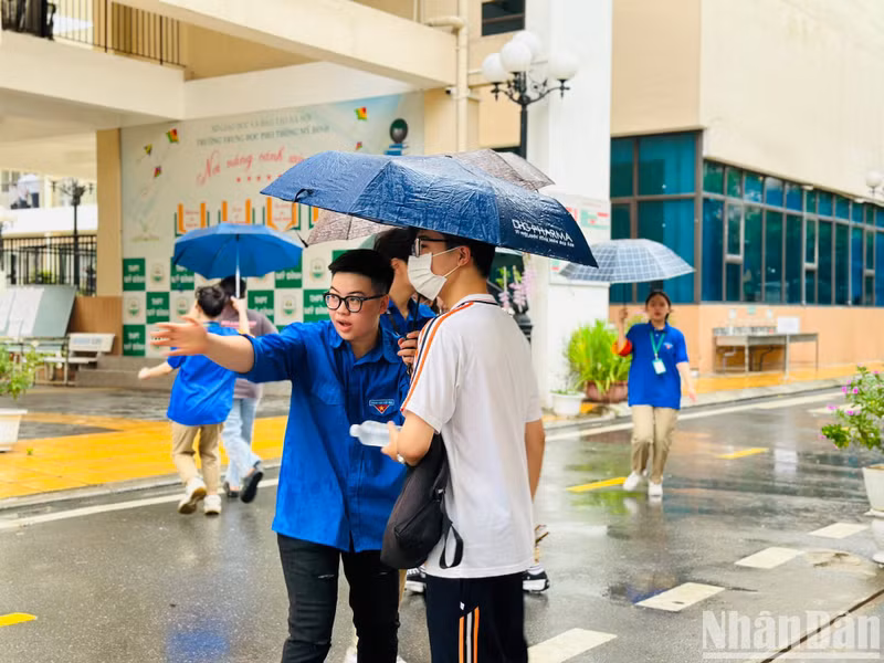 A volunteer gives instruction to a candidate on the way to the exam venue.