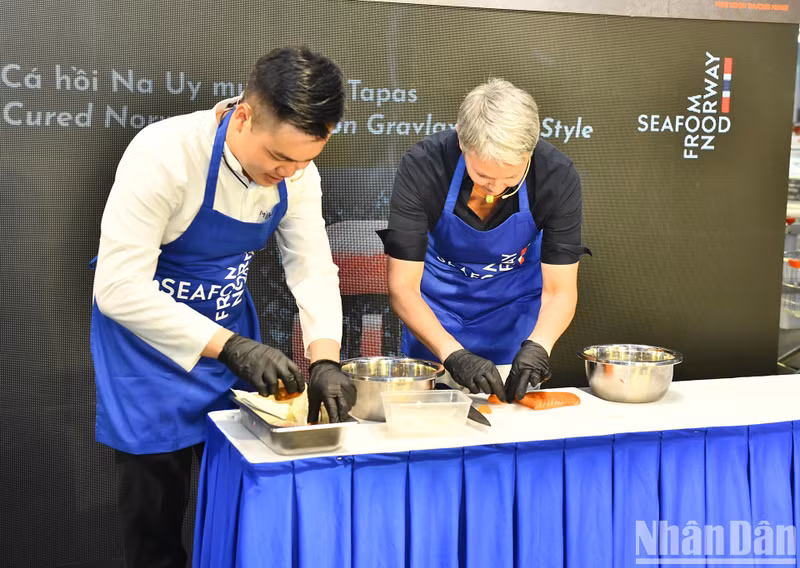 Norwegian Ambassador to Vietnam Hilde Solbakken joins a professional chef in processing and cooking top-class Norwegian salmon.