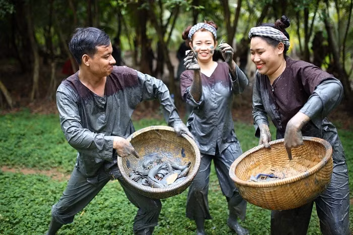 Visitors join fish catching game in Yen Trung tourism village in Yen Dinh district, Thanh Hoa province (Photo: dulichvietnam.com.vn)