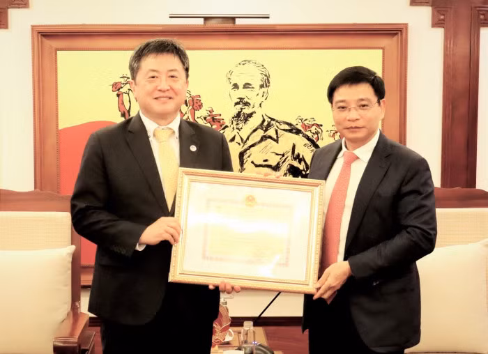 Minister of Transport Nguyen Van Thang (right) presents the insignia “For the development of Vietnam's transport sector” to Shimizu Akira, Chief Representative of the Japan International Cooperation Agency (JICA) Vietnam Office (Photo: baogiaothong.vn)