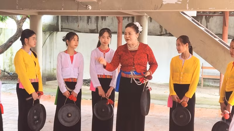Dinh Thi Kieu Dung instructing local children on playing gongs