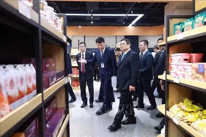 Prime Minister Pham Minh Chinh visits the booths selling Vietnamese products at the Chongqing International Logistics Hub Park. (Photo: VNA)